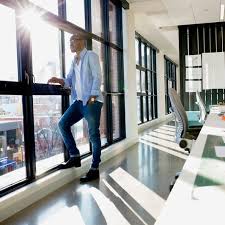man standing near windows in office