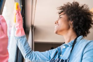 smiling woman cleaning window